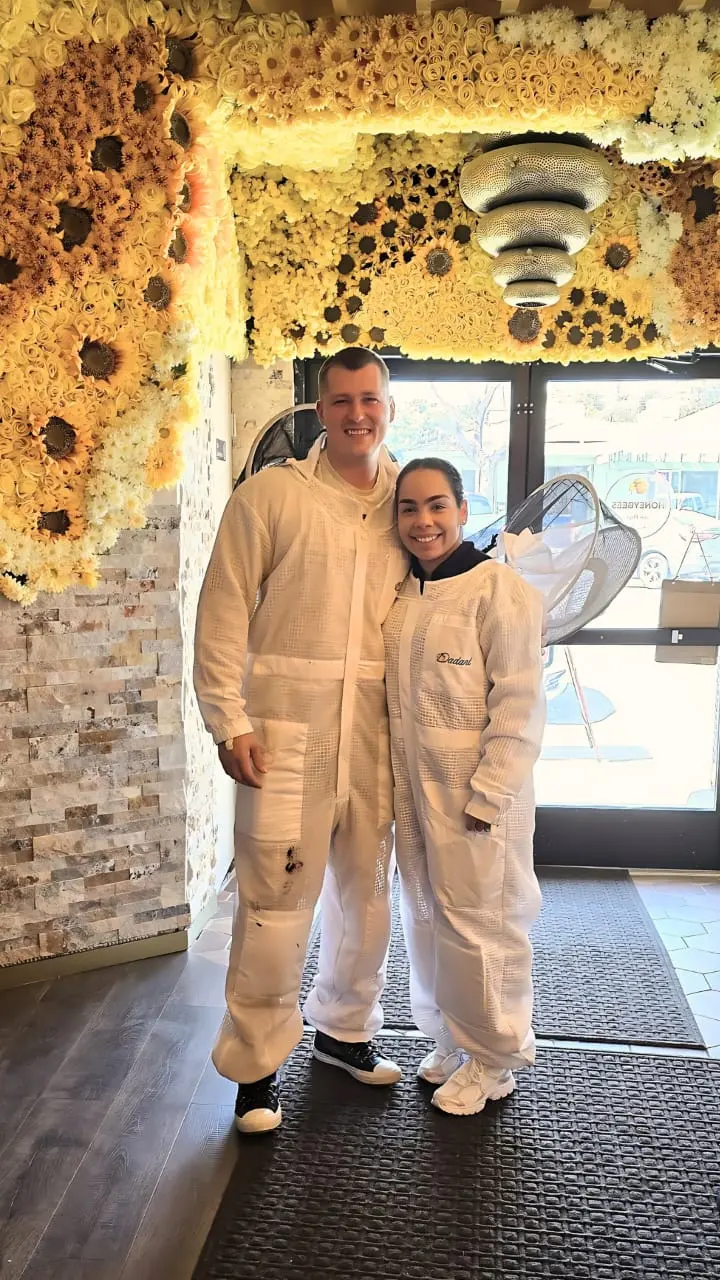 Eli the Bee Guy and his wife in their beekeeping suits